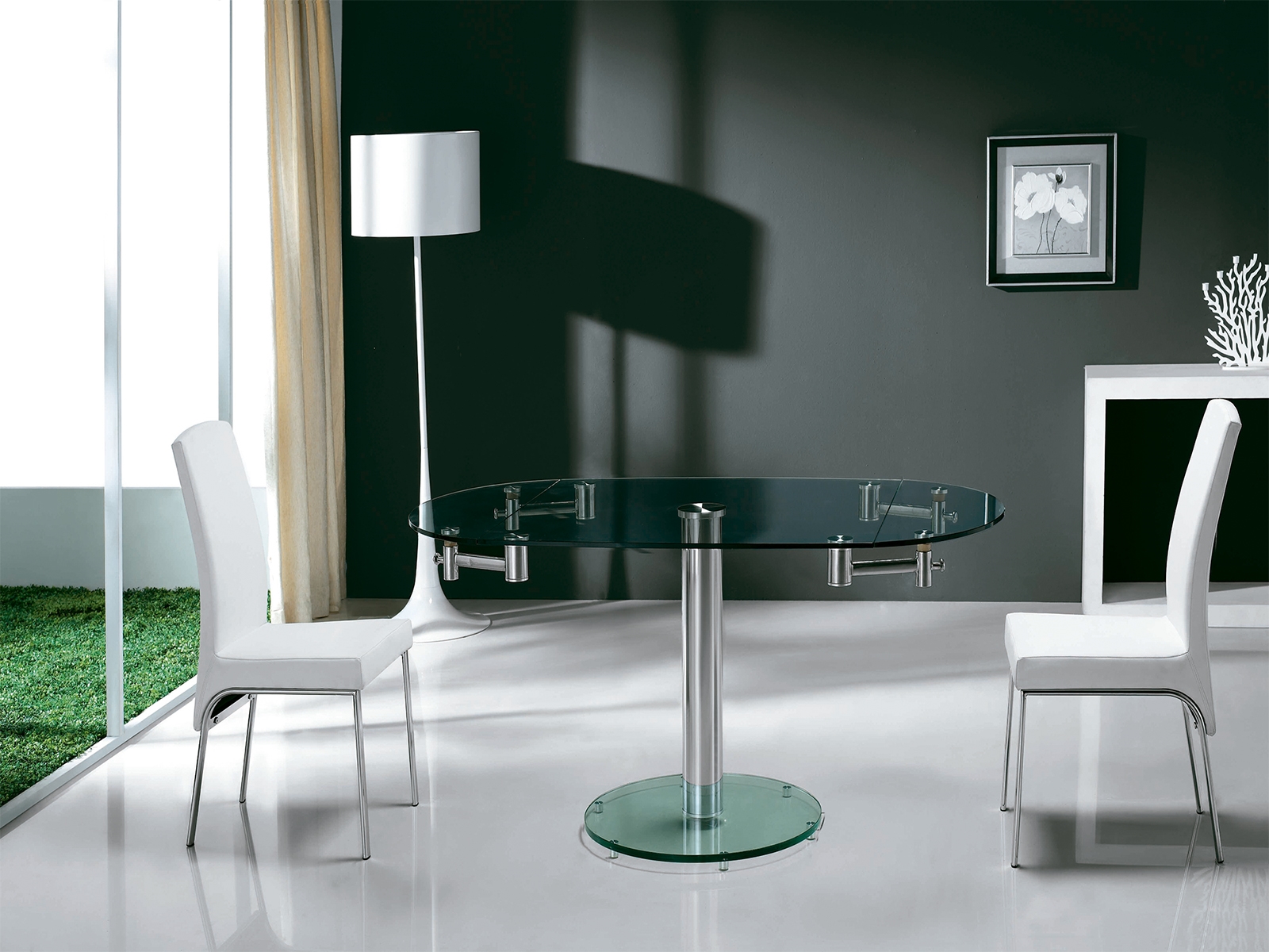Thao manual dining table with stainless base and clear top.